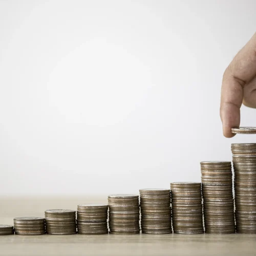 Münzstapel und Dokumente als Symbol für Kostenvergleich